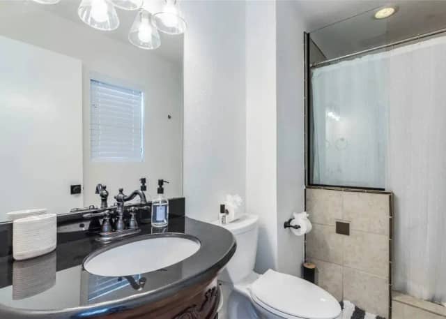 Bathroom with dark granite vanity and shower