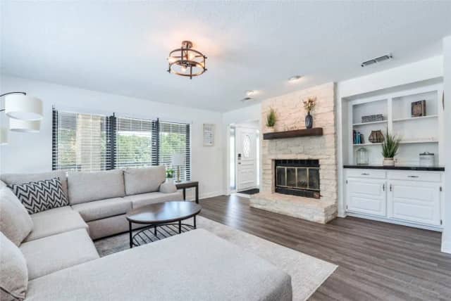 Living room with stone fireplace and built-in shelves