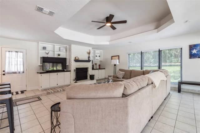 Living room with tray ceiling and fireplace